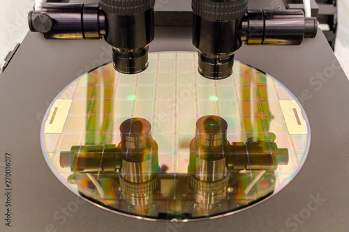 Silicon wafer on machine process examining in microscope.