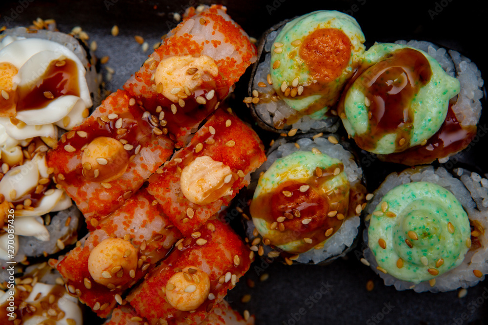set of different sushi rolls on black background close-up set of different sushi rolls on black background close-up