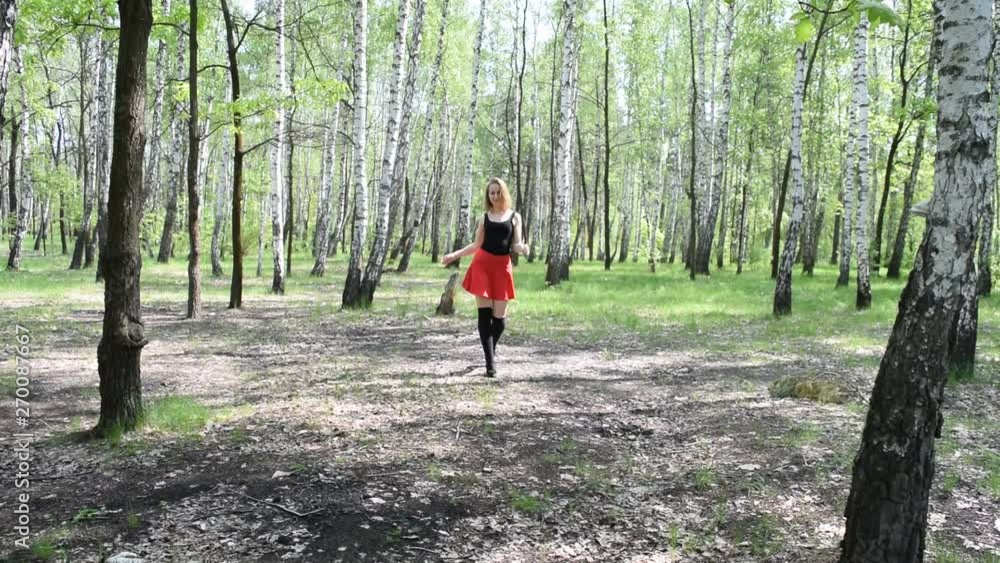 Young girl in short dress walking in the woods. Young girl in short dress walking in the woods.