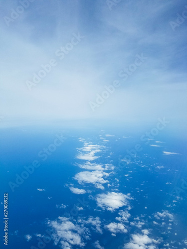 Photo taken above and between layers of clouds over the ocean