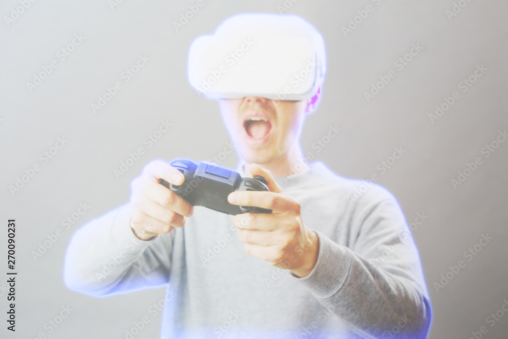 Man with virtual reality headset is playing game. Image with hologram effect. Man with virtual reality headset is playing game. Image with hologram effect.