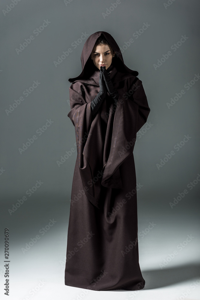 full length view of smiling woman in death costume showing please gesture on grey