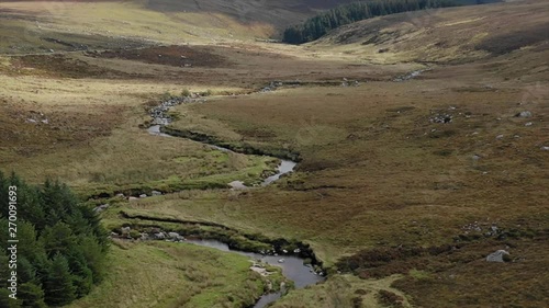 Drone flying over river in mountain valley on an Autumn day