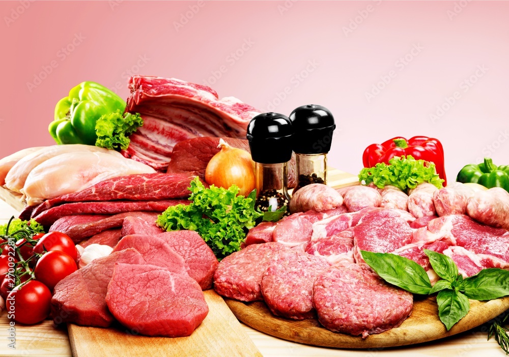 Fresh raw meat background with vegetables on wooden desk isolated on white background Fresh raw meat background with vegetables on wooden desk isolated on white background