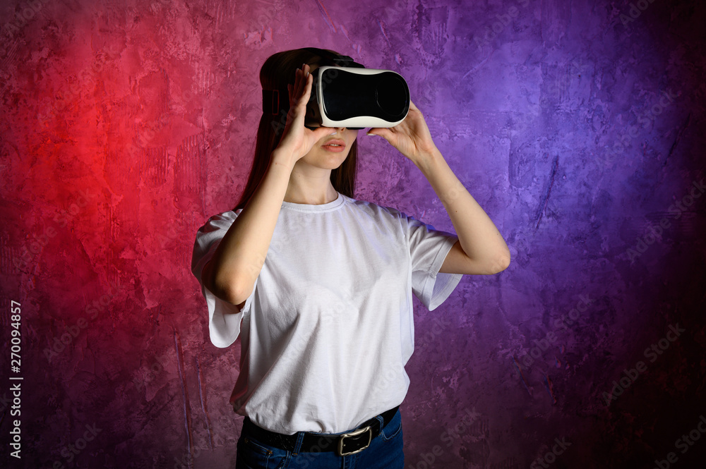 Young woman touching the air during the VR experience. Blue and red background Young woman touching the air during the VR experience. Blue and red background