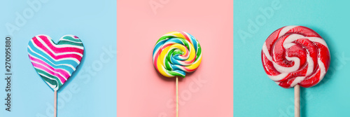Three colorful lollipops candy as heart and swirl on blue and pink. Funny concept. Top view. Collage.