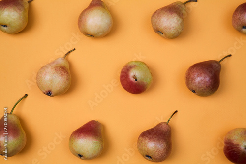 Ripe juicy pears placed on orange background. Colorful fruit pattern or background. photo