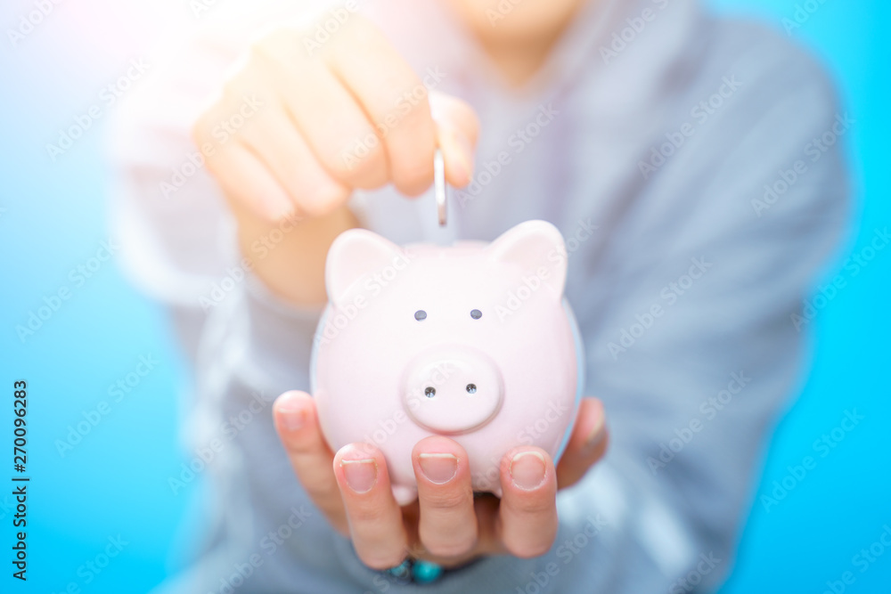 Photo of man throwing coin into piggy bank Photo of man throwing coin into piggy bank