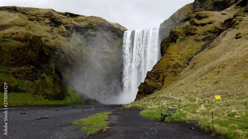 Beautiful Iceland Waterfall with cloudy skies and rocks and grass