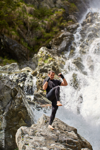 Muay thai fighter training by the waterfall