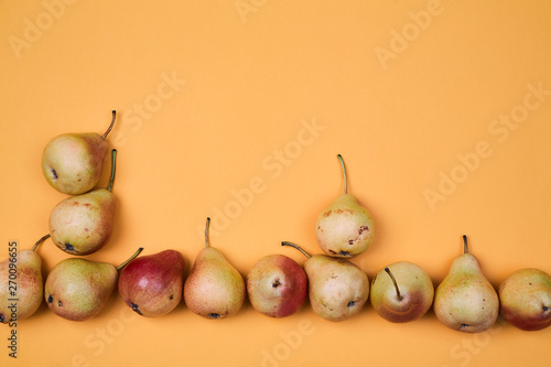 Pears placed as pattern on orange background. Colorful fruit pattern or background photo