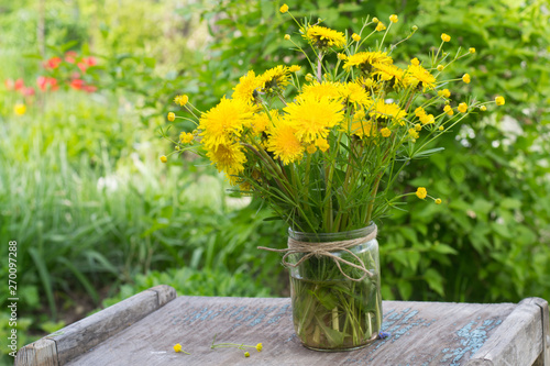 Bouquet of dandelions in glass jar