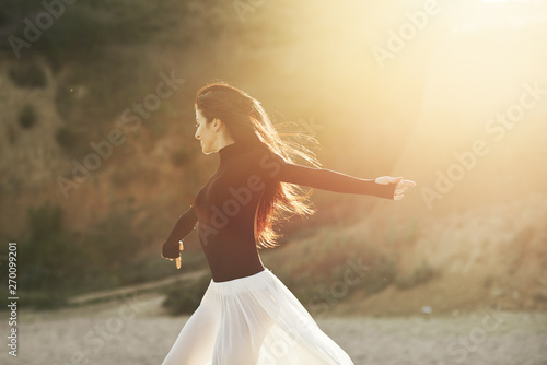 Ballet woman Dancer at Sunset beach. Classical dance in white chiffon skirt