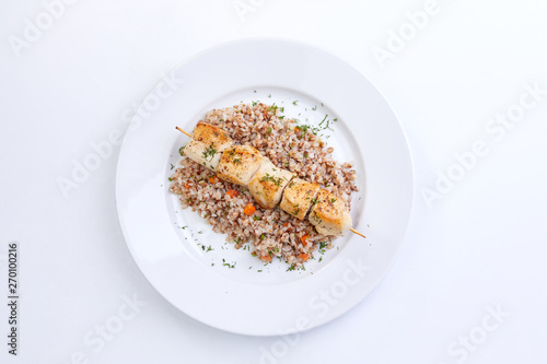 chicken kebab with buckwheat on the white plate