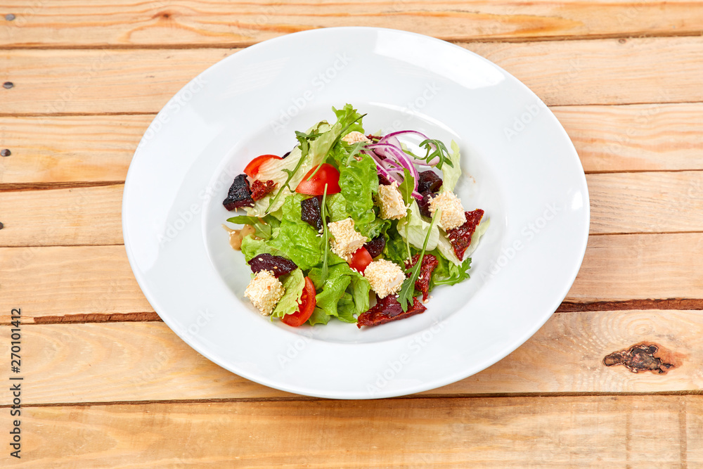 vegetarian salad with dried tomatoes and croutons on the wooden background vegetarian salad with dried tomatoes and croutons on the wooden background