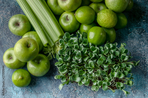 Top view green apples, celery, limes and milk thistle microgreen on a concrete background. Detox program, diet plan, weight loss.