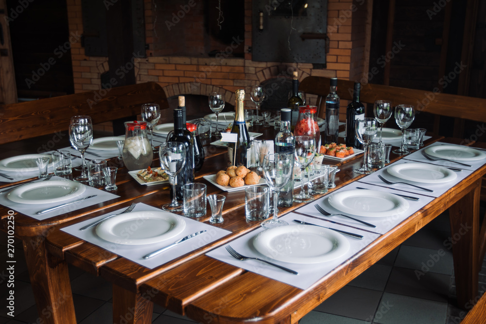 Glasses, forks, knives, plates on a table in restaurant served for dinner. Glasses, forks, knives, plates on a table in restaurant served for dinner.
