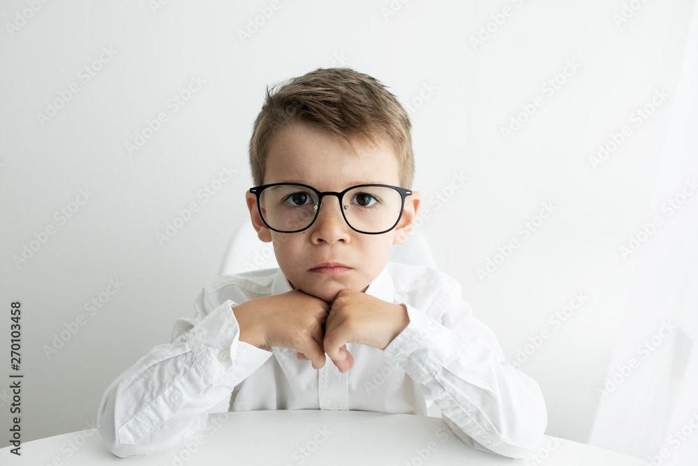 Cute little boy using laptop while doing homework against white background Cute little boy using laptop while doing homework against white background