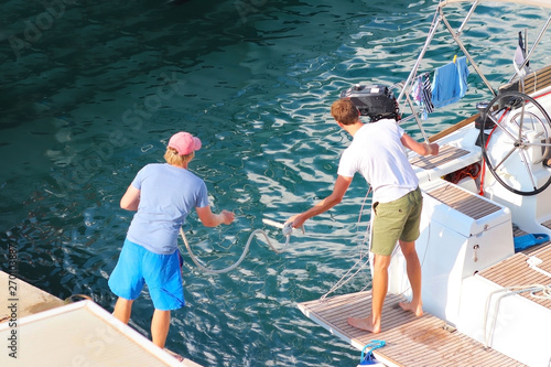 Foto Two sailors moor the sailing cruise yacht to the marina pier