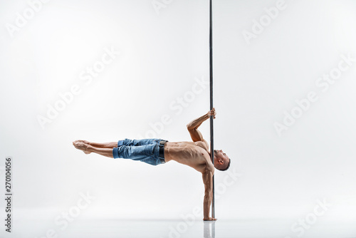 Young pole dance male athlete with white background