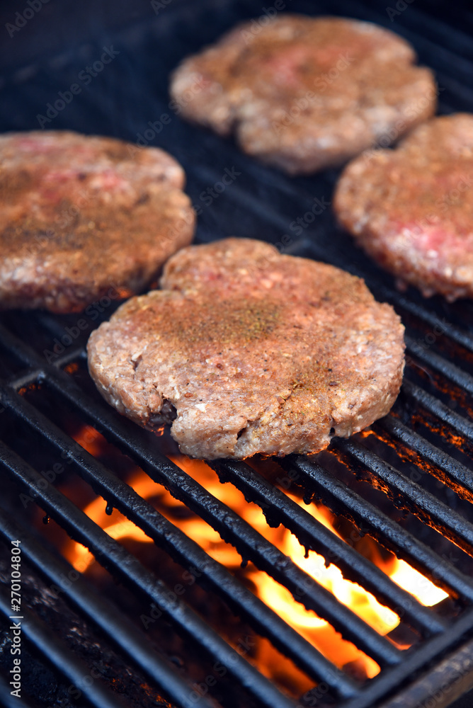 Grilling seasoned burgers on a barbecue Grilling seasoned burgers on a barbecue