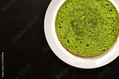 green round spinach mint cake on a white plate on a black background