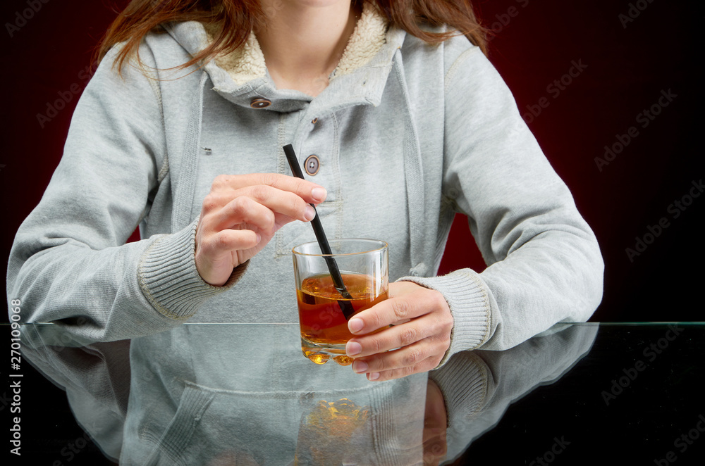 Girl and alcoholic drink with straw and ice on red background Girl and alcoholic drink with straw and ice on red background