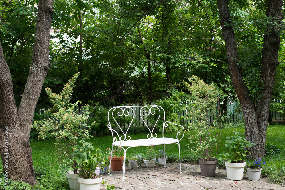 White bench with a bush. garden. green background. Background