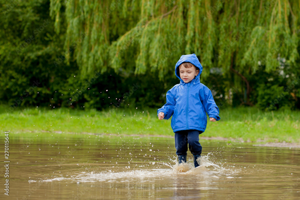 Portrait of cute kid boy playing with handmade ship. kindergarten boy sailing a toy boat by the waters' edge in the park Portrait of cute kid boy playing with handmade ship. kindergarten boy sailing a toy boat by the waters' edge in the park