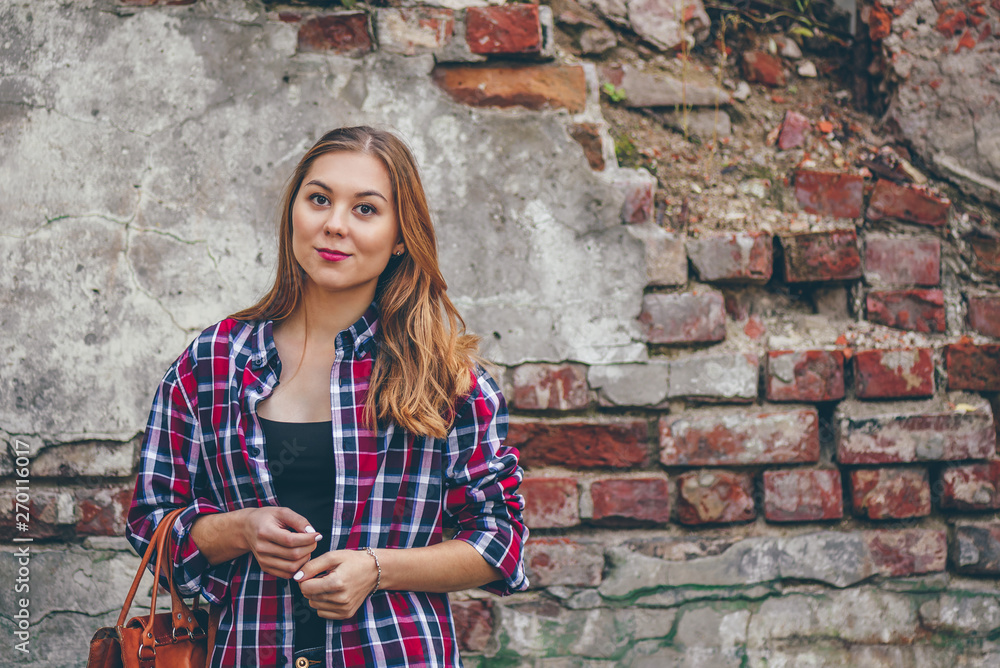 Beautiful girl is standing against brick wall Beautiful girl is standing against brick wall