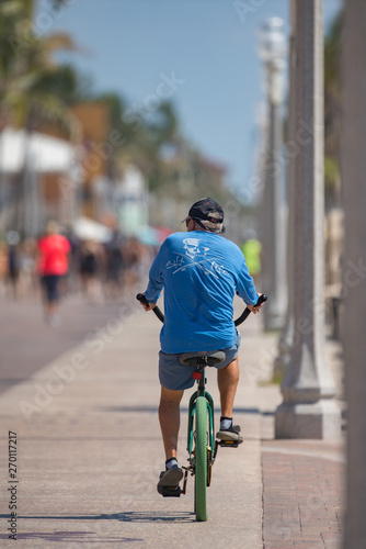 Image of a senior man riding a bike on Hollywood Beach FL © Felix Mizioznikov