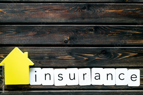 Insurance copy with house figure on wooden background top view mock up