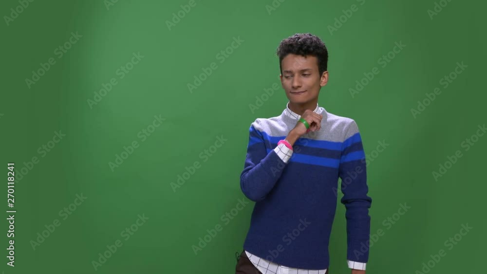 Closeup shoot of young attractive indian male dancing with joy looking at camera with background isolated on green Closeup shoot of young attractive indian male dancing with joy looking at camera with background isolated on green