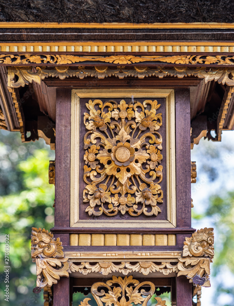 Dusun Ambengan, Bali, Indonesia - February 25, 2019: Clan compound. Closeup of golden decoration square on one of the memorials for ancestors.