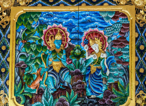 Dusun Ambengan, Bali, Indonesia - February 25, 2019: Clan compound. Closeup of Lord Shiva and Devi Parvati painting on side of altar in shrine comes in vivid colors and gold. photo