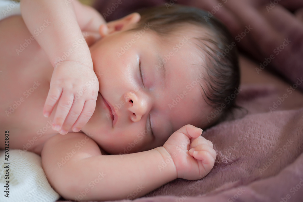 closeup of beautiful newborn baby asleep on a violet blanket closeup of beautiful newborn baby asleep on a violet blanket