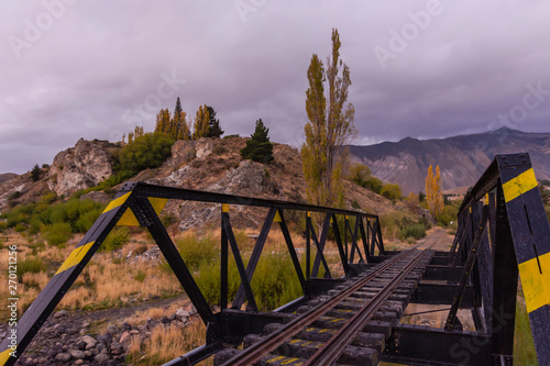 Scene view of an iron railway bridge against mountains in sunset