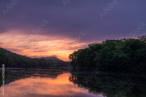 Moody sunrise over Delaware Water Gap, Pennsylvania featuring lake on the foreground and mountains on the background © TetyanaOhare