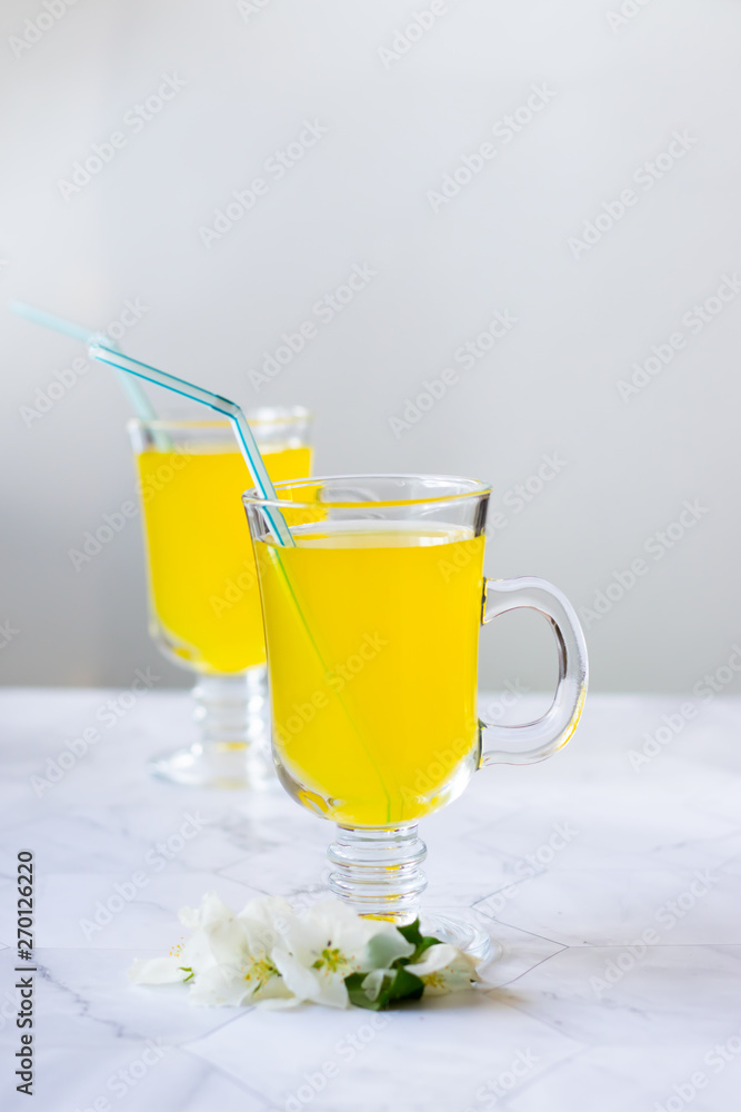 Lemonade refreshing drink in a glass beaker on a light background Lemonade refreshing drink in a glass beaker on a light background