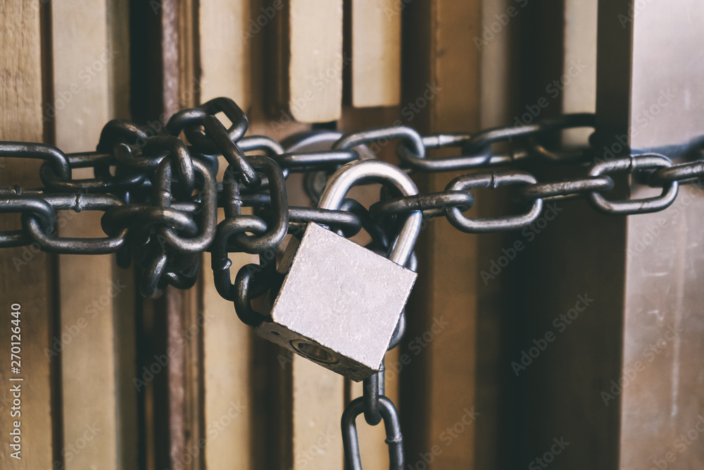 High Security Locked Door by Brass Padlock and Big Chain. Safety and Security Concept. High Security Locked Door by Brass Padlock and Big Chain. Safety and Security Concept.