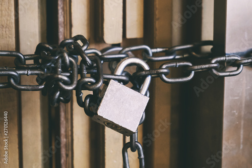 High Security Locked Door by Brass Padlock and Big Chain. Safety and Security Concept.