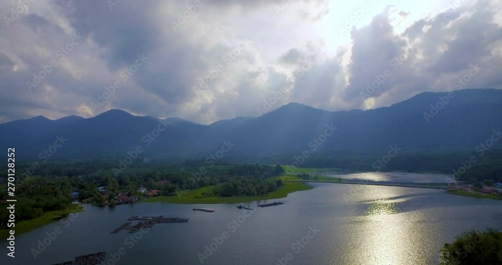 Aerial Shot of Raban Lake with Mountain, Fish Farm and Forrest during beautiful Sunset with God Ray, Malaysia Aerial Shot of Raban Lake with Mountain, Fish Farm and Forrest during beautiful Sunset with God Ray, Malaysia