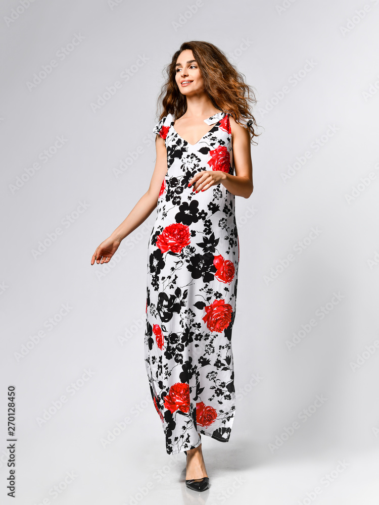 Young beautiful woman posing in new red flower pattern fashion dress on white background. Fashion spring summer photo Young beautiful woman posing in new red flower pattern fashion dress on white background. Fashion spring summer photo