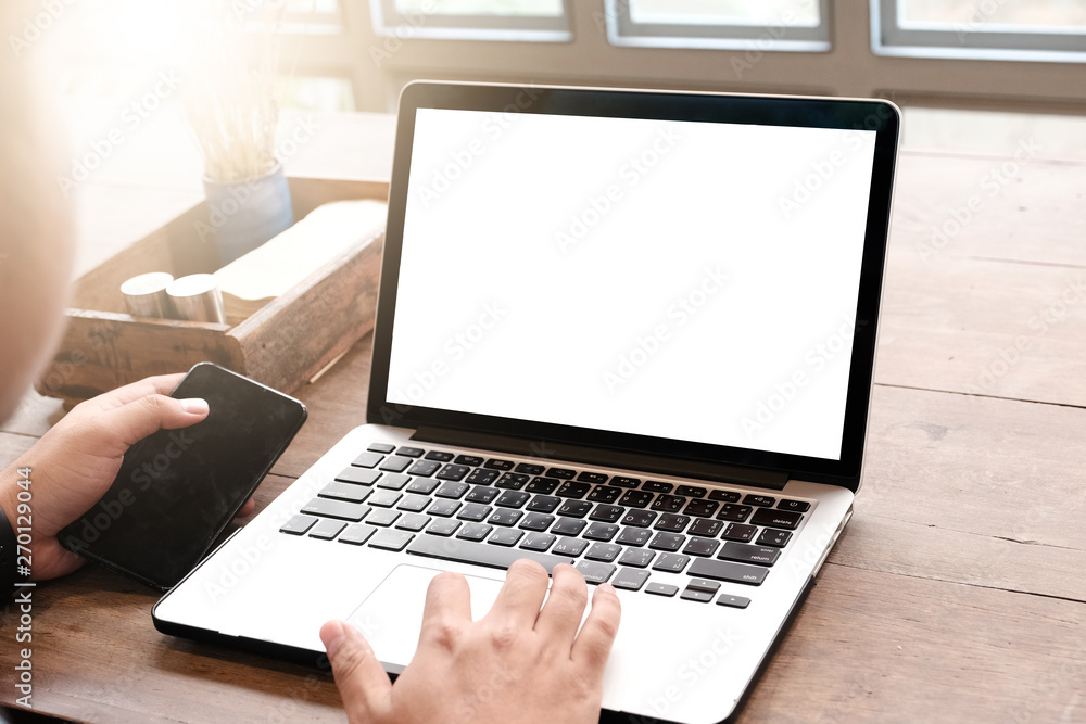 Mockup image of a businesswoman using laptop with blank white desktop screen with coffee cup on wooden table in cafe Mockup image of a businesswoman using laptop with blank white desktop screen with coffee cup on wooden table in cafe