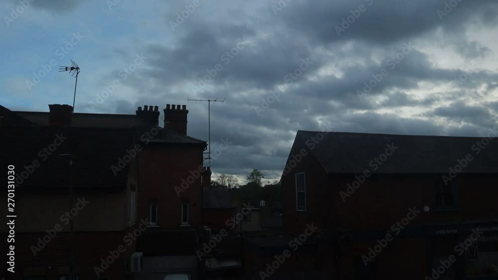 Time lapse of the clouds over buildings. The sky gets gradually darker as the day goes on and the clouds get thicker. Time lapse of the clouds over buildings. The sky gets gradually darker as the day goes on and the clouds get thicker.