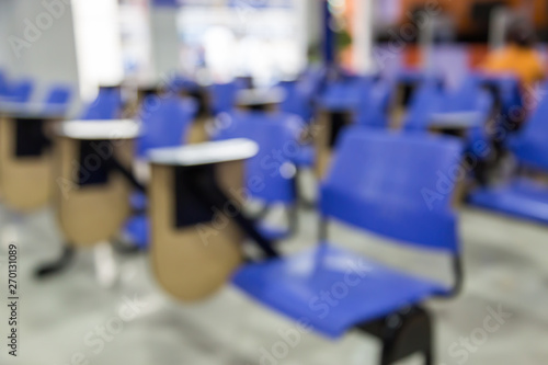 Defocus of tables and blue chairs in empty classroom