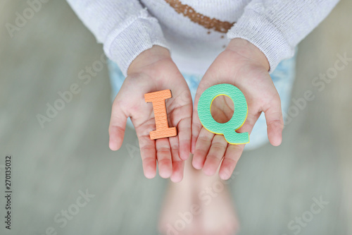 IQ (Intelligence Quotient) sponge text on child hands. Education and development concept.