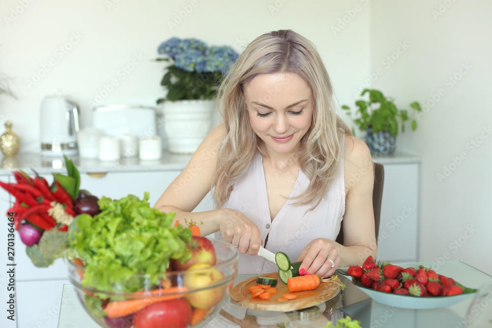 young positive smiling woman with vegetables in the kitchen young positive smiling woman with vegetables in the kitchen