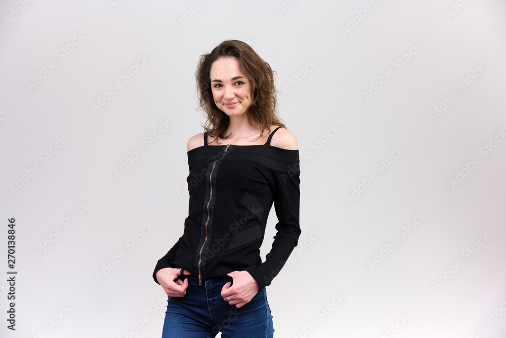 Life is a success. I am pleased with myself. Concept photo of a happy smiling woman satisfied life contented brunette girl in a black T-shirt and jeans on a gray background with flowing hair. Life is a success. I am pleased with myself. Concept photo of a happy smiling woman satisfied life contented brunette girl in a black T-shirt and jeans on a gray background with flowing hair.