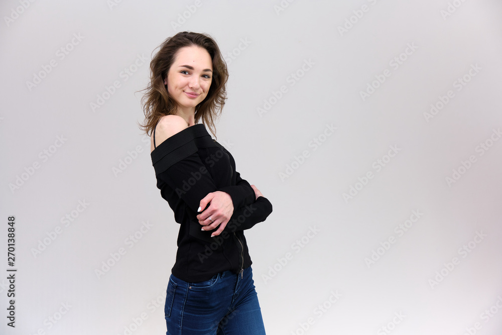 Life is a success. I am pleased with myself. Concept photo of a happy smiling woman satisfied life contented brunette girl in a black T-shirt and jeans on a gray background with flowing hair. Life is a success. I am pleased with myself. Concept photo of a happy smiling woman satisfied life contented brunette girl in a black T-shirt and jeans on a gray background with flowing hair.